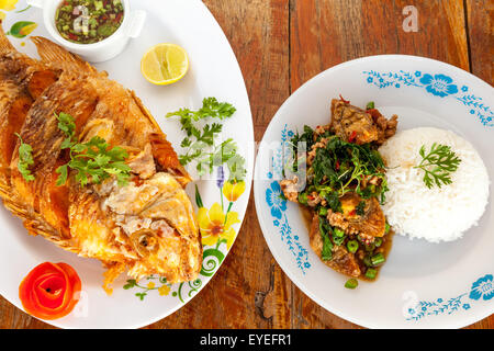 Thai fried fish and cooked on a plate with lemon and the peel of an tomato Stock Photo