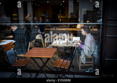 Young female using computer in a cafe, London, UK Stock Photo