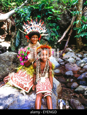 Woman with tattooed face and young boy in traditional dress; Tufi, Papua New Guinea Stock Photo