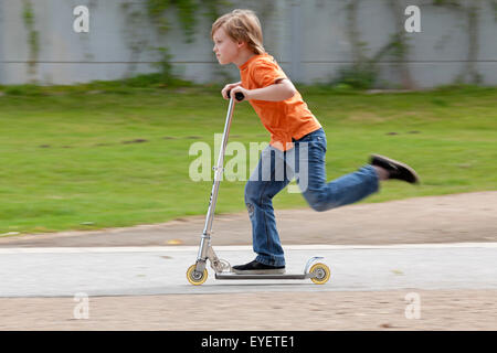 young boy on a scooter Stock Photo