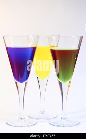 Three cocktails of bright colored alcohol against a white background Stock Photo