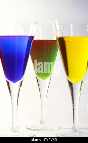 Three cocktails of bright colored alcohol against a white background Stock Photo