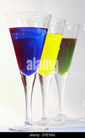 Three cocktails of bright colored alcohol against a white background Stock Photo