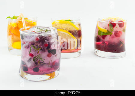 Natural fruit iced-T juice with ice, lemon and sliced fruits in a crooked glass on white Stock Photo