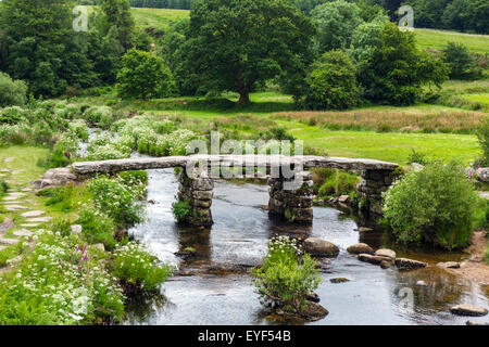 The historic clapper bridge over the East Dart River in Postbridge, Dartmoor, Devon, England, UK Stock Photo