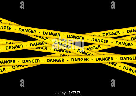 Yellow caution tape strips with text of danger, on black background. Stock Photo