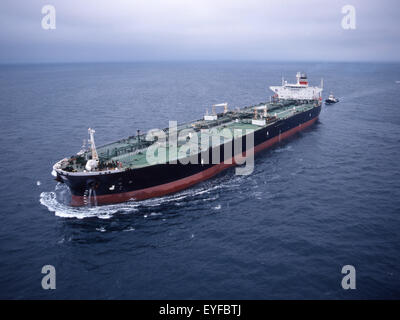 oil tanker steaming at sea with tug Stock Photo
