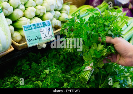 Man choosing parsley in market stall Stock Photo