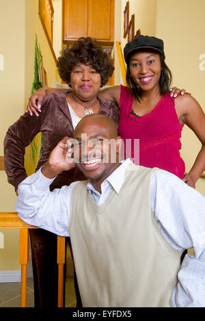 An African American middle class couple and their aunt pose in their living room in Corona, CA. Stock Photo