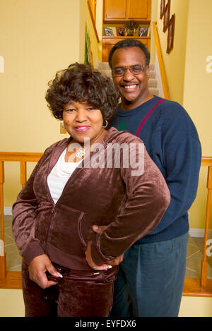 An African American middle class couple pose in their living room in Corona, CA. Stock Photo