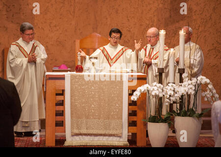 A Vietnamese American priest is assisted by a bishop (right) and a monsignor (left) celebrating mass at a Laguna Niguel, CA, Catholic church Stock Photo