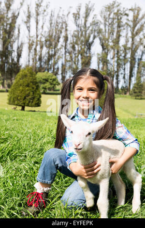 Portrait of girl (6-7) holding lamb Stock Photo