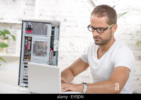young engineer repaired a computer with laptop Stock Photo