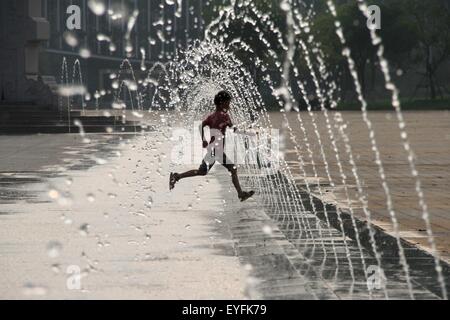 Binzhou, China's Shandong Province. 26th July, 2015. A boy enjoys coolness in his summer vacation at a fountain in Binzhou, east China's Shandong Province, July 26, 2015. © Zhang Binbin/Xinhua/Alamy Live News Stock Photo