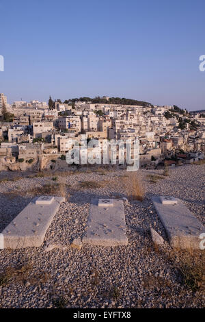 View of old Jewish Tombs and the Palestinian neighborhood of Silwan or Siloam across the hill in East Jerusalem Israel Stock Photo