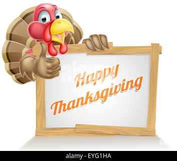 Thanksgiving sign with cartoon turkey bird giving a thumbs up above a sign reading Happy Thanksgiving Stock Photo