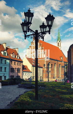 Street lamp in a square in the center of Riga in the summer on a background of old houses and flowers Stock Photo
