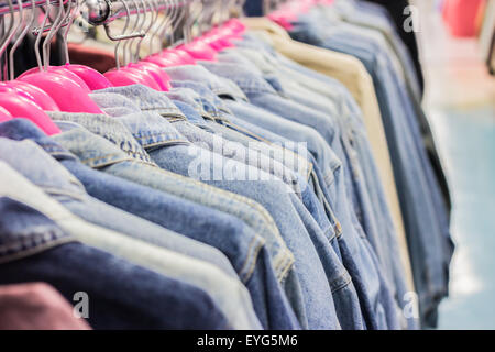 Row of different female clothes hanging on rack in hipster fashion