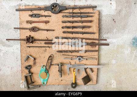 old work tools hanging in wall garage Stock Photo