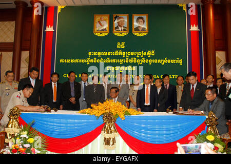 Phnom Penh, Cambodia. 29th July, 2015. Huang Yichuan (1st R, front), representative of China Fujian Zhongya Culture Media Company, signs an agreement with Gen. Mao Bunarith (1st L, front), director general of Cambodian Interior Ministry's general department of logistics and finance, with the presence of Cambodian Deputy Prime Minister and Interior Minister Sar Kheng (C, front) in Phnom Penh, Cambodia, July 29, 2015. Credit:  Xinhua/Alamy Live News Stock Photo