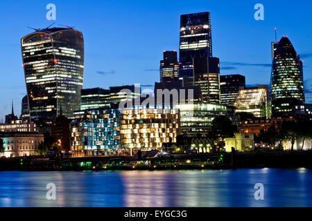 Night skyline of London famous modern glass skyscrapers in financial with water reflections in Thames river Stock Photo