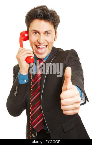 Cheering winner on the phone holding his thumb up Stock Photo