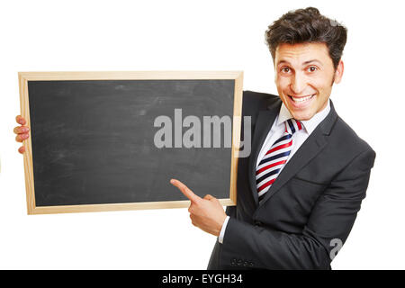 Happy business man pointing to empty black chalkboard Stock Photo