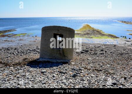 World War II lookout post sinking into the pebbly beach at Kimmeridge Bay, Dorset, UK. Stock Photo