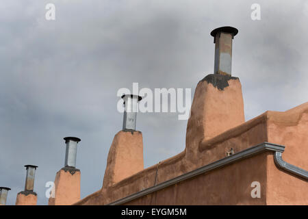 Row of chimneys on adobe building in Old Town district of Albuquerque, New Mexico.  Copy space in sky above architectural detail Stock Photo
