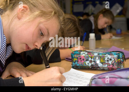 Secondary school pupils studying and writing in classroom, Surrey, UK. Stock Photo