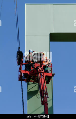 Two Worker installing a metal bridgehead in a harbor Stock Photo