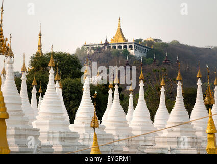 Golden Sandamuni Pagoda with row of white pagodas. Amazing architecture of Buddhist Temples at Mandalay, Burma Stock Photo