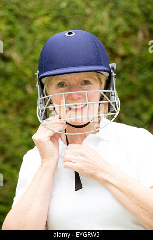 Portrait of an elderly woman cricketer wearing a batswoman's safety helmet Stock Photo