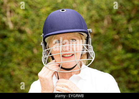 Portrait of an elderly woman cricketer wearing a batswoman's safety helmet Stock Photo