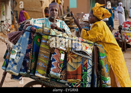 Niger, Tuareg men shopping for garments at Housa trader's stall. Agadez's livestock market; Agadez Stock Photo