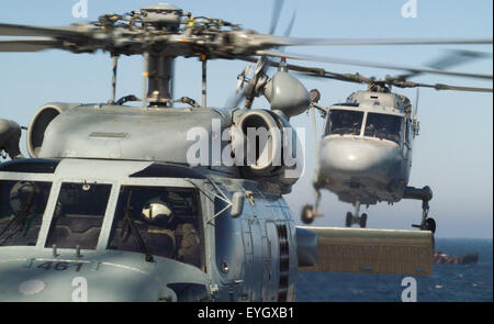 Nato cooperation a US Navy Seahawk helicopter on the deck of HMS Albion while a French Navy Lynx helicopter comes in to land. Stock Photo