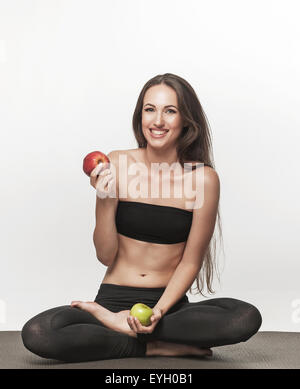 https://l450v.alamy.com/450v/eyh0b1/young-brunette-woman-sitting-on-yoga-mat-woman-holding-apple-healthy-eyh0b1.jpg