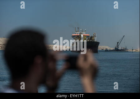 Ismailia, Egypt. 29th July, 2015. A man takes photos on the new Suez Canal in Ismailia, a port city in Egypt, on July 29, 2015. The dredging work of Egypt's 'New Suez Canal' has been completed and the waterway is ready as well as safe for huge ship navigation, Mohab Memish, head of the Suez Canal Authority (SCA), told reporters in a press conference Wednesday. © Pan Chaoyue/Xinhua/Alamy Live News Stock Photo