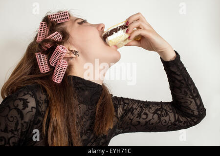 Young hungry gluttonous woman eating pie Stock Photo
