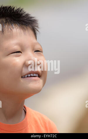 Portrait of a little mongoloid boy happy and smiling with copy space Stock Photo
