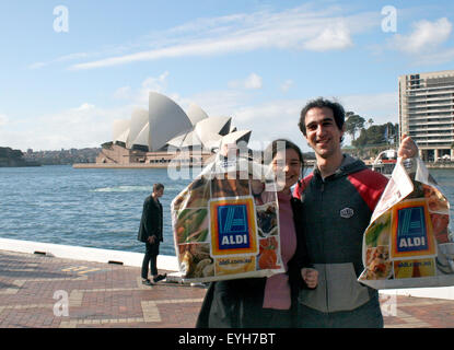 Sydney, Australia. 19th July, 2015. Aldi customers Hannah Walker (26) and Mike Weekes (29) stand at the Opera House in Sydney, Australia, 19 July 2015. German supermarket chain Aldi is expanding with now even more stores in the country. The competition has even tried taking a swipe at the chain's reputation, without success. Photo: Photo: Frank Walker/dpa/Alamy Live News Stock Photo