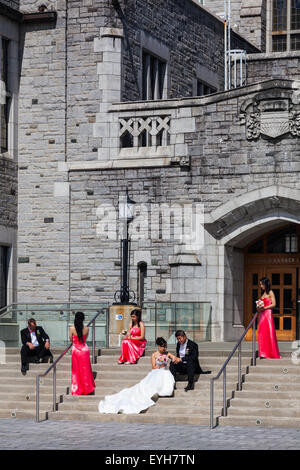Asian couple with their wedding party having photographs made on the steps of the Learning Centre at UBC in Vancouver Stock Photo