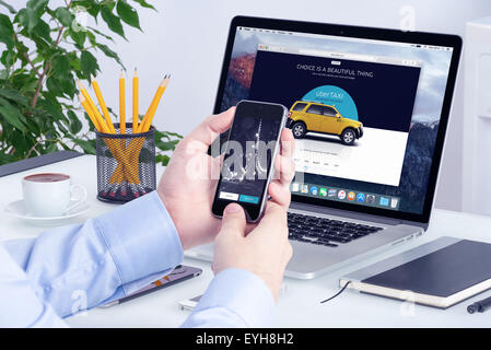 Varna, Bulgaria - May 29, 2015: Uber application on Apple iPhone display and desktop version of Uber on Apple Macbook Pro. Stock Photo