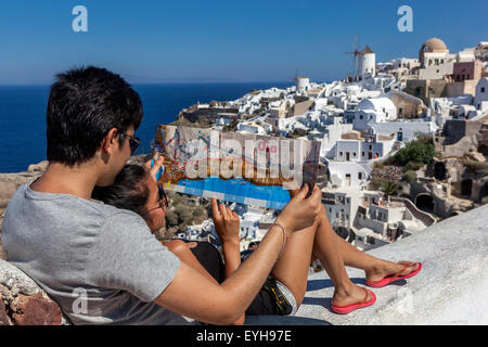 Young Asian people with a village map Oia Santorini Tourist couple lovers, Greek Island, Greece travel Europe tourists Stock Photo