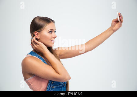 Portrait of a cute girl making selfie photo on smartphone isolated on a white background Stock Photo