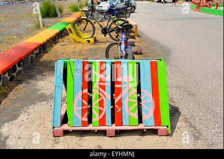 A colorful bike rack made out of a wooden pallet on Perissa beach Santorini Greece Stock Photo