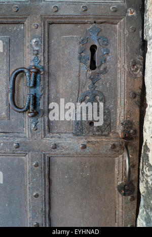 England. Old wooden door with big keyhole and metal handles. Stock Photo