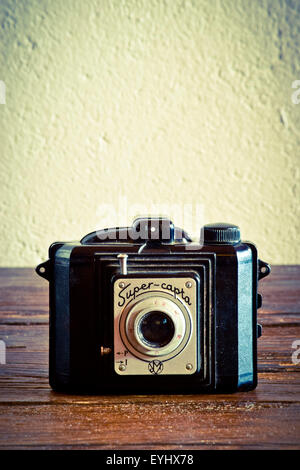 Old camera on wooden surface. Stock Photo