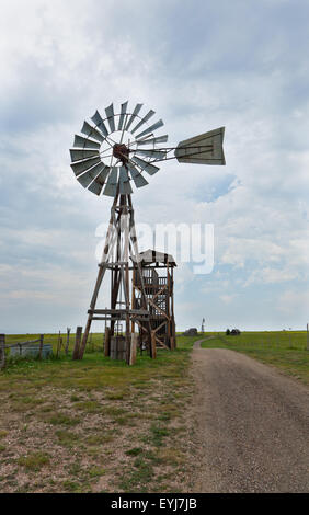 An old western windmill, used to pump water out of a well, made of wood and metal on a prairie farm in South Dakota. Stock Photo