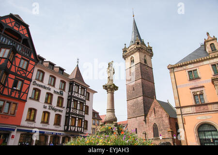OBERNAI, FRANCE - MAY 11, 2015: Chapel tower, Sainte Odile fountain and town hall on the market square of Obernai, Bas-Rhin, Als Stock Photo